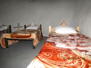 a bedroom with two beds and a table at Libibing chalets in Mokhotlong