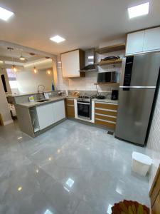 una cocina con electrodomésticos de acero inoxidable y armarios blancos en lugar de sonhar em copacabana, en Río de Janeiro