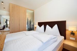 a white bed with white pillows in a bedroom at Gasthof Weber in Petersberg