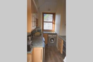 a kitchen with a washer and a washing machine at Mallaig Self Catering Apartment in Mallaig