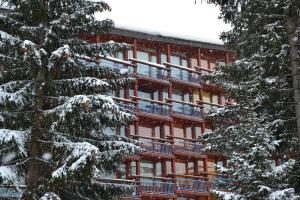 阿克1800的住宿－ARC 1800, Résidence les Lauzieres，前面有雪覆盖的树木的建筑