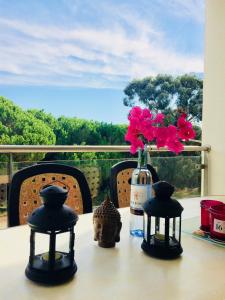 uma mesa com uma garrafa de vinho e flores em Delightful vacations apartment in Algarve nos Olhos de Água