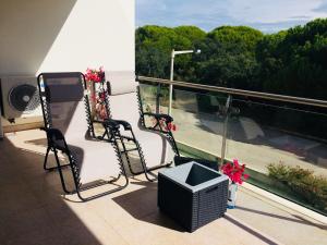 Duas cadeiras sentadas numa varanda com vista em Delightful vacations apartment in Algarve nos Olhos de Água