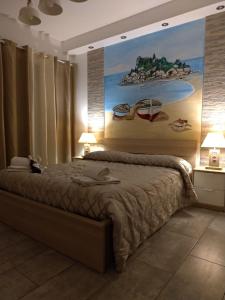 
a bedroom with a large bed and a painting on the wall at B&B My Sicily in Giardini Naxos
