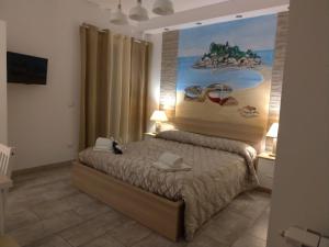
a bedroom with a bed and a painting on the wall at B&B My Sicily in Giardini Naxos
