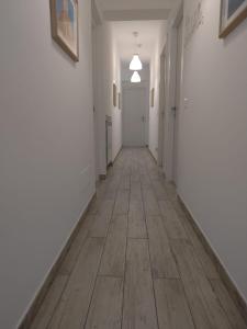 un corridoio vuoto con pareti bianche e pavimenti in legno di B&B My Sicily a Giardini Naxos