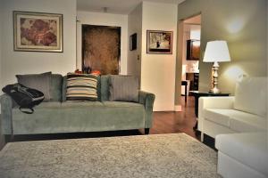 uma sala de estar com um sofá verde e uma cadeira branca em Arhaus 3 em Grand Forks