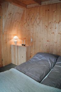 a bedroom with a bed in a wooden wall at Múlafossur Cottage No 3 by Famous Waterfall in Gásadalur in Gásadalur