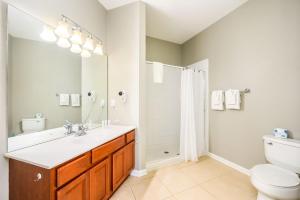 a bathroom with a toilet, sink and mirror at Vista Cay Resort by Millenium at Universal Blvd. in Orlando