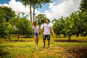 Ein Mann und eine Frau gehen durch einen Apfelgarten in der Unterkunft The Lodge At Uxmal in Uxmal