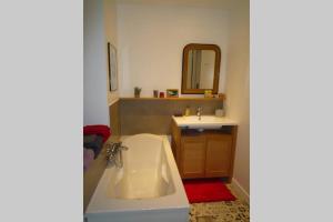 a bathroom with a bath tub and a sink at Le Clos 25 in Chalon-sur-Saône +35 photos