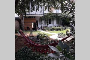 a garden with a hammock in front of a house at Le Clos 25 in Chalon-sur-Saône