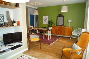 a living room with a table and a dining room at Le Clos 25 in Chalon-sur-Saône