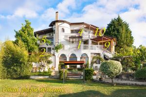 a large white house with a large yellow sign on it at Villa Zelenika in Sinemorets