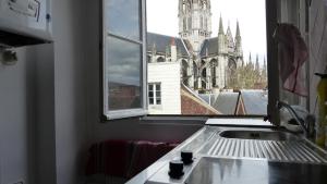 a kitchen window with a view of a church at Rouen Hyper Centre Cathédrale Hotel de ville in Rouen