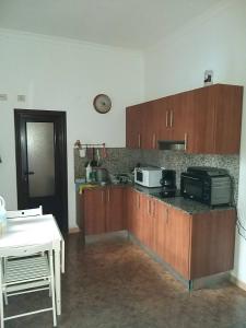 a kitchen with wooden cabinets and a counter top at Numero28,Casa Tilama in Uga