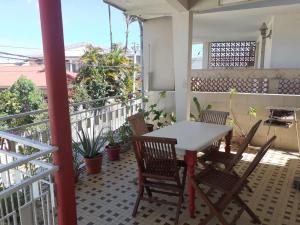 Un patio con una mesa y sillas en un balcón. en Maison YZIDEE, en Fort-de-France