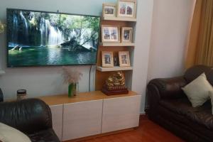 a living room with a flat screen tv on a wall at A un minuto del aeropuerto Siéntase como en casa in Cusco