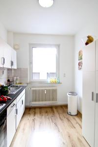 a kitchen with white cabinets and a window at apartmondo Ferienwohnungen Wuppertal in Wuppertal