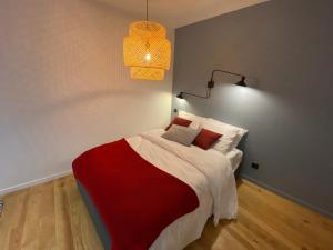a bedroom with a bed with a red and white blanket at Le Charme - Au Coeur d'Agen - Self Checkin - Wifi - Netflix - Smart TV - Luqs fr in Agen
