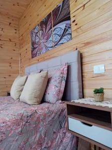 朋雷提羅的住宿－Cabana Caminho das Borboletas，一间卧室设有一张床和木墙