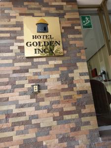 庫斯科的住宿－金印加酒店，砖墙,上面有酒店金色的旅馆标志