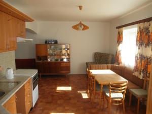 eine Küche und ein Wohnzimmer mit einem Tisch und einem Sofa in der Unterkunft Chlalupa se zahradou - Chlum u Třeboně in Chlum u Třeboně