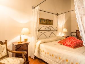 um quarto com uma cama de dossel e uma cadeira em Belvilla by OYO Il Vecchio Frantoio em Orciatico
