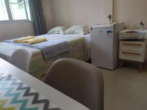 Habitación con 1 cama con nevera y sillas. en Copacabana Ipanema Comfortable Studio, en Río de Janeiro