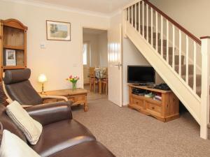 sala de estar con sofá y TV en Anvil House, en Weymouth