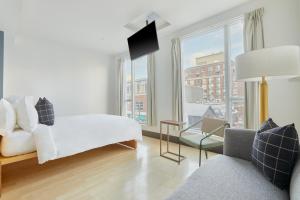 a white room with a bed and a large window at Sonder The Beverley in Toronto
