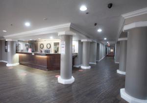 a lobby with columns and a counter in a building at Ramada by Wyndham Barstow in Barstow