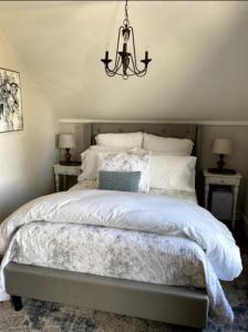 a bedroom with a bed with a chandelier above it at The Farmhouse Inn & Kitchen, 2 blocks from Downtown Whitefish, Montana in Whitefish