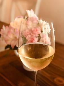 a glass of wine with a vase of flowers at The Farmhouse Inn & Kitchen, 2 blocks from Downtown Whitefish, Montana in Whitefish