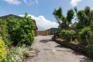 une allée dans un jardin avec une clôture et des fleurs dans l'établissement Be Our Guest Cottage, à Truro