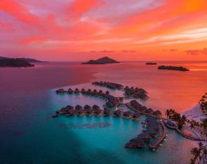 - une vue aérienne sur l'océan au coucher du soleil dans l'établissement Le Bora Bora by Pearl Resorts, à Bora Bora