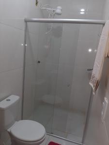 uma casa de banho com uma cabina de duche em vidro e um WC. em Casa de dois quartos em Carolina