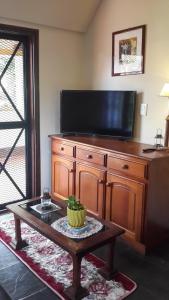 uma sala de estar com uma televisão e uma mesa de centro em Casa Folks em Puerto Iguazú