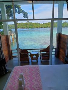 a view of the ocean from a room with a table and chairs at Mr. Bean Resort in Sabang +22 photos