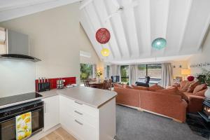 a kitchen and living room with a couch at Wharerata - Otaki Beach Holiday Home in Otaki Beach