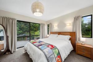 a bedroom with a bed and a large window at Wharerata - Otaki Beach Holiday Home in Otaki Beach
