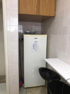 a white refrigerator in a kitchen with two black stools at Apartamento mobiliado prédio frente ao mar in São Vicente +35 photos