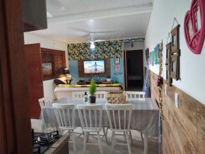 a dining room and living room with a table and chairs at Casa ,piscina há 100 metros do mar ,24 pessoas in Capão da Canoa