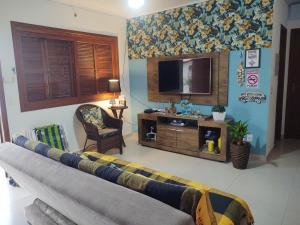 a living room with a couch and a television at Casa ,piscina há 100 metros do mar ,24 pessoas in Capão da Canoa