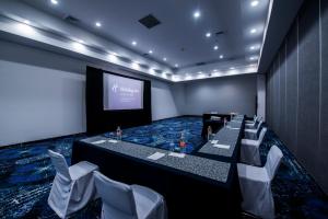 una sala de conferencias con una mesa larga, sillas y una pantalla en Ramada by Wyndham Ciudad de Mexico Perinorte, en Ciudad de México