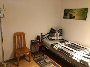 ein kleines Schlafzimmer mit einem Bett und einem Stuhl in der Unterkunft Ferienwohnung Tom in Schnaittenbach
