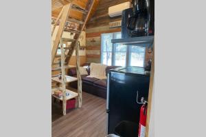 a tiny house with a staircase and a living room at The Cowboy Cabin in Marble Falls