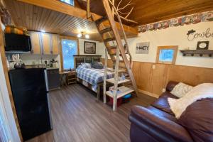 a bedroom with a bed and a kitchen and a living room at The Cowboy Cabin in Marble Falls