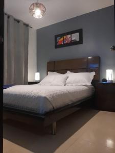 1 dormitorio con cama y lámpara de araña en PREMIER APARTMENT., en Cúcuta