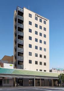 a large white building with a sign on it at Remington Hotel in Akashi